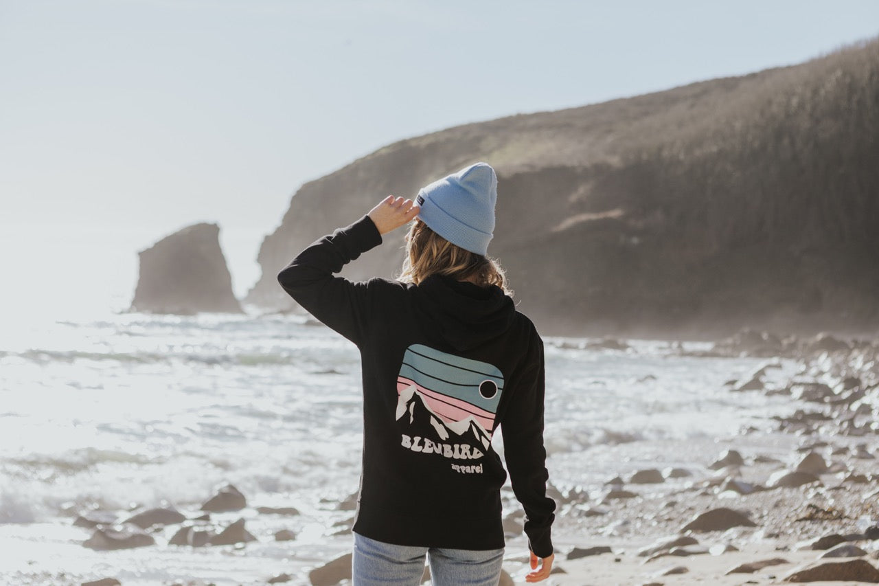 Woman standing on the sea shore with hoodie