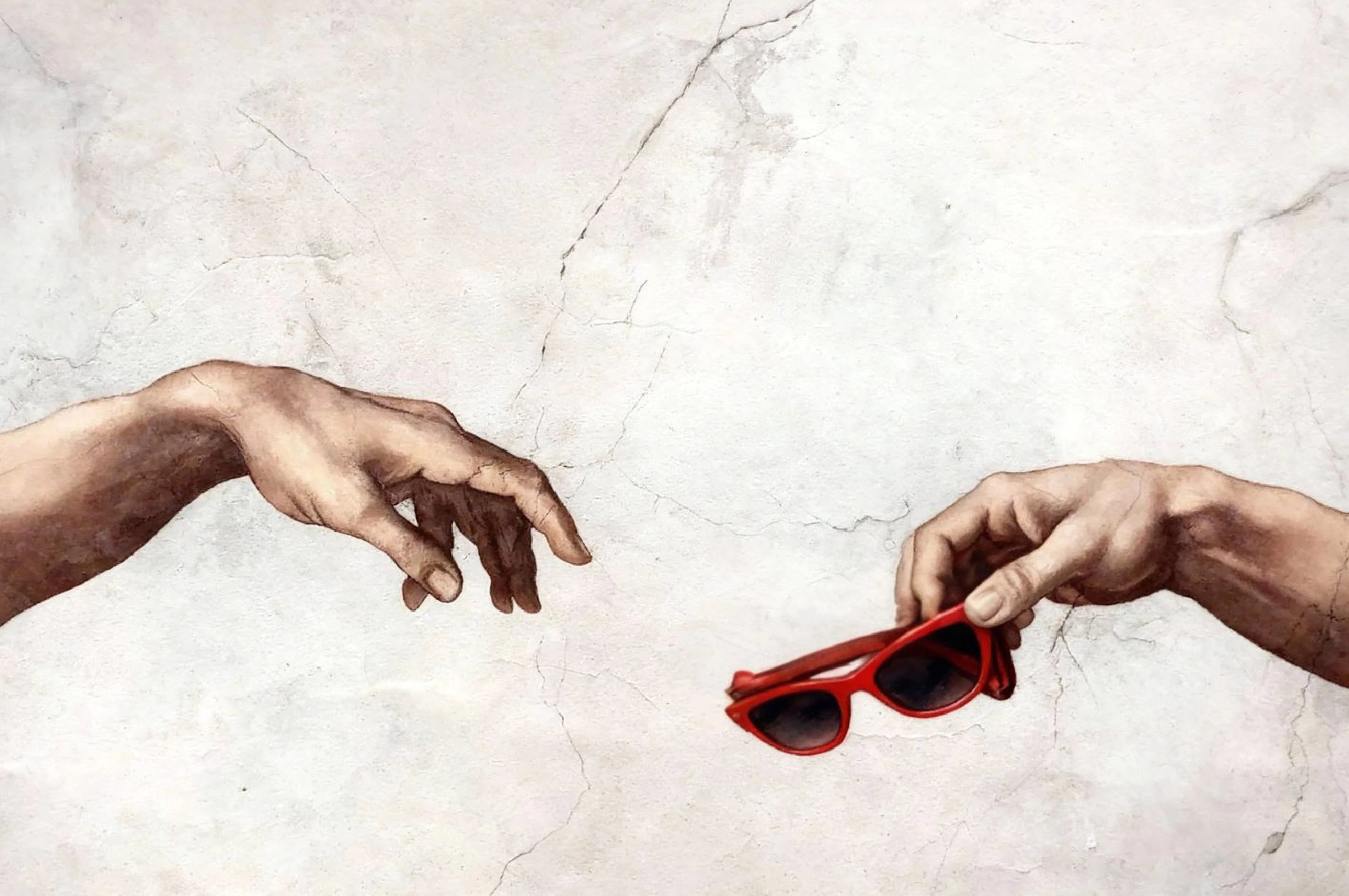 Two hands reaching towards each other with red sunglasses on a textured white background