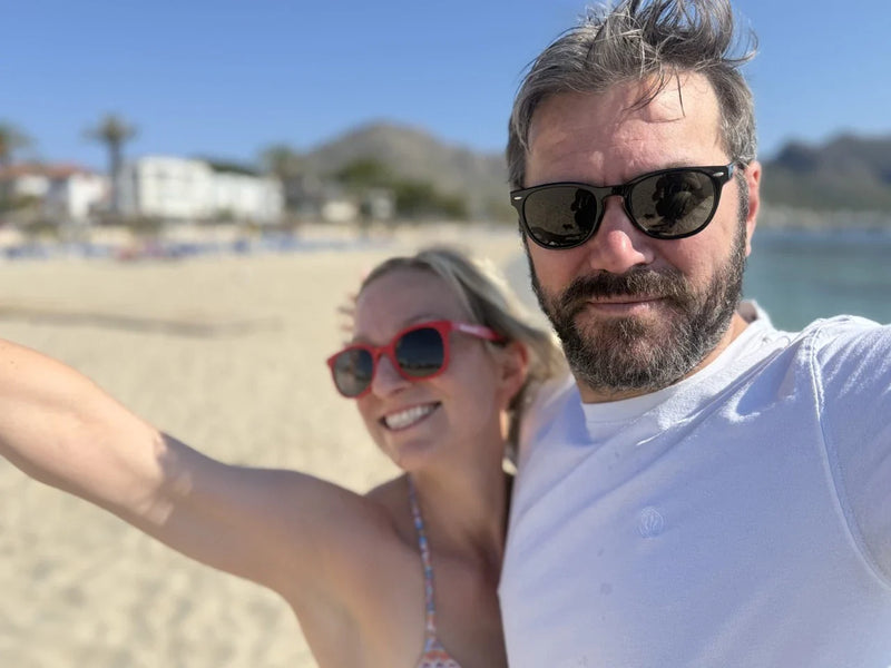 Man and woman on beach wearing eco beach sunglasses