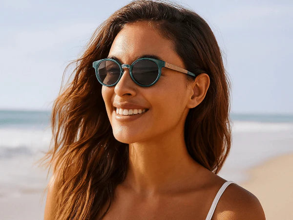 Woman lying in the sun on a beach wearing a bikini and Wildwood sunglasses