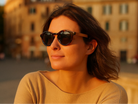 Woman wearing sunglasses with a blurred building in the background