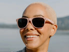 Person wearing pink sunglasses with a blurred natural background