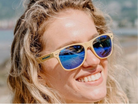 Person wearing sunglasses with a blurred natural background