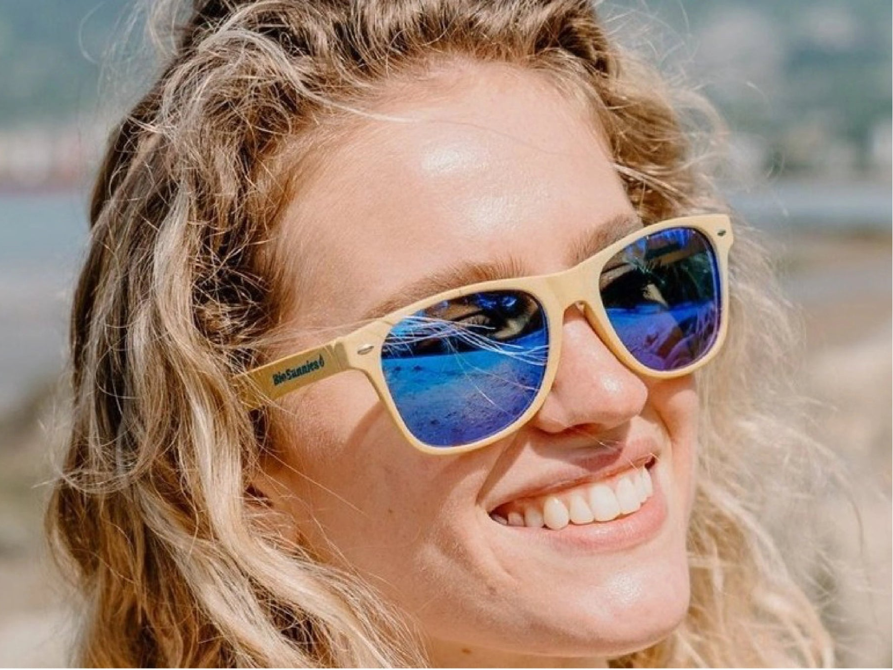 Person wearing sunglasses with a blurred natural background