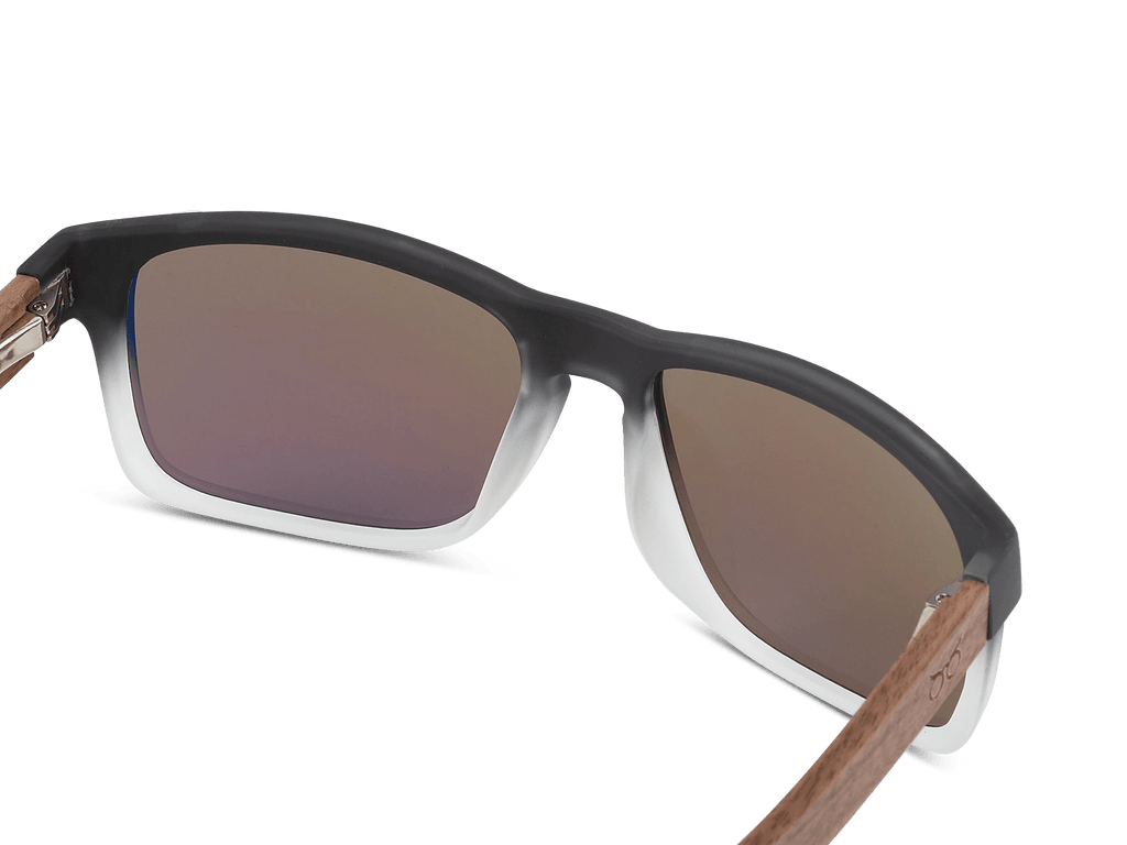 Sunglasses with brown gradient lenses and wooden arms on a white background