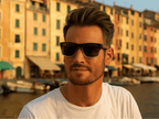 Man wearing sunglasses with a colorful building background