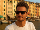 Man wearing sunglasses with a colorful building background