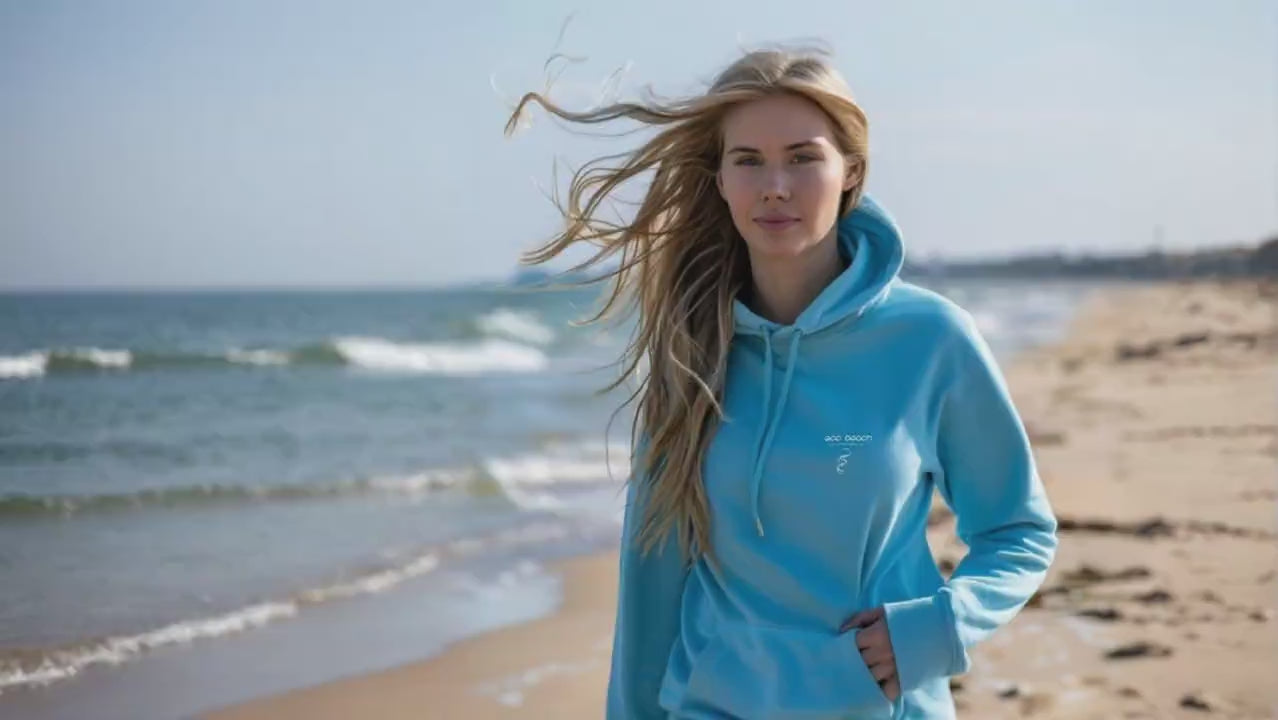 Woman in blue Eco Beach hoodie walking down the beach